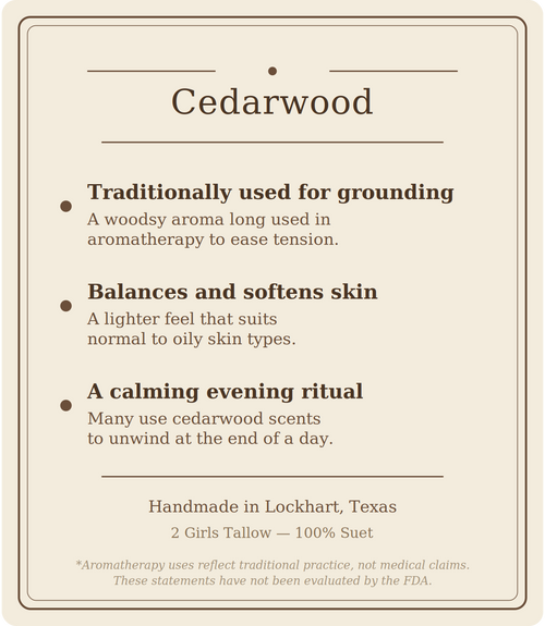 Beige card titled "Cedarwood" listing three points: traditionally used for grounding (a woodsy aroma long used in aromatherapy to ease tension), balances and softens skin (a lighter feel that suits normal to oily skin types), and a calming evening ritual (many use cedarwood scents to unwind at the end of a day). Footer reads "Handmade in Lockhart, Texas. 2 Girls Tallow, 100% suet," followed by a note that aromatherapy uses reflect traditional practice, not medical claims, and that these statements have not 